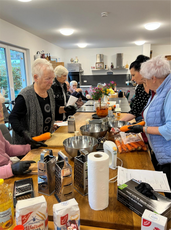 Seniorinnen kochen gemeinsam in einer betreuten Wohngruppe